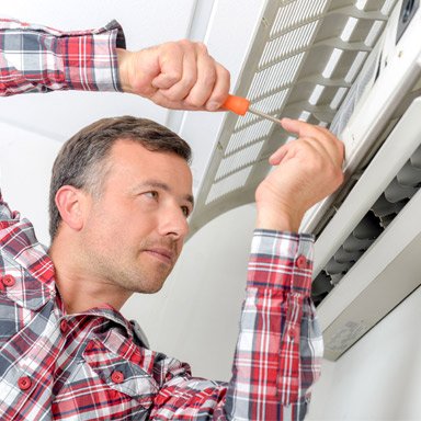 Technician performing ductless mini-split repair in Vancouver home — Ace Tech HVAC